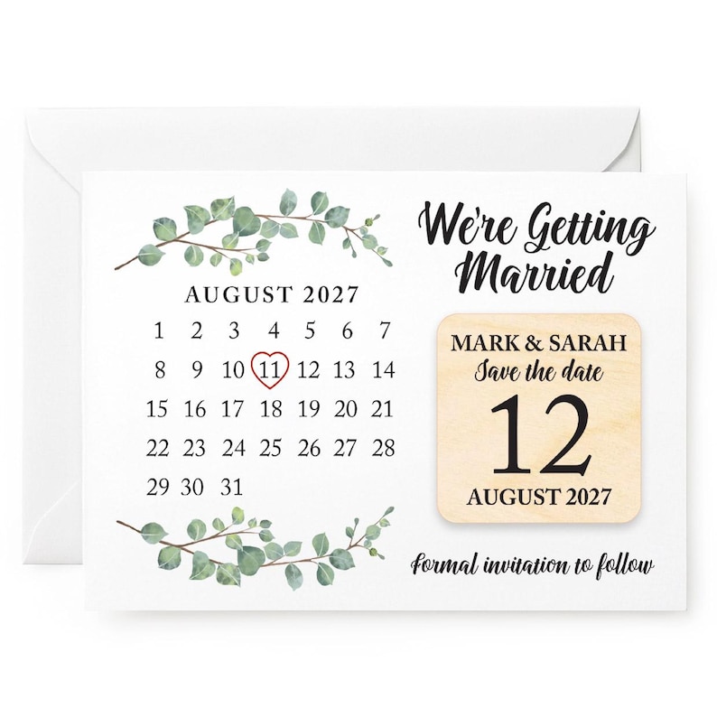 May include: A white save-the-date card featuring a calendar for August 2027, with the 11th circled in red. The card reads "We're Getting Married" and has a wooden accent with the date August 12, 2027, for Mark & Sarah. Includes eucalyptus.