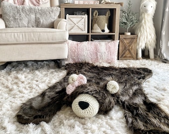 Alfombra de oso pardo de piel sintética para la decoración de una habitación infantil con temática de bosque.