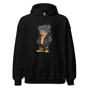 May include: Black hoodie with a cartoon illustration of a bear wearing a black and yellow jacket and black and yellow sneakers.