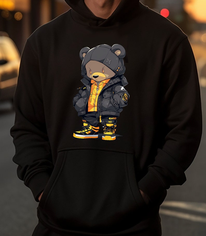 May include: Black hoodie with a graphic of a cartoon bear wearing a black and yellow puffer jacket and sneakers.