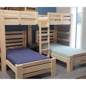 May include: A wooden bunk bed with a ladder and two single mattresses. The bed is made of natural wood and has a simple design. The top bunk has a guardrail and the bottom bunk has a headboard and footboard.