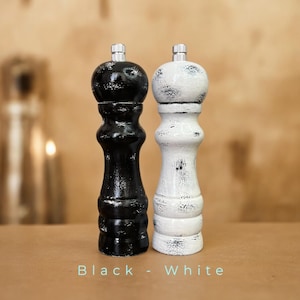 May include: Black and white salt and pepper shakers with a distressed finish. The shakers are made of wood and have a classic design.