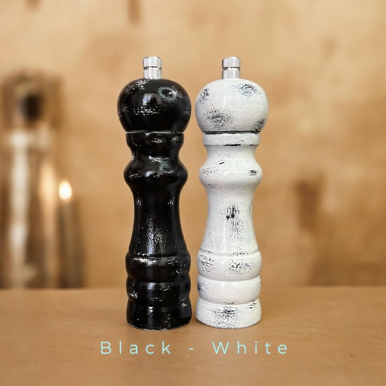 May include: Black and white salt and pepper shakers with a distressed finish. The shakers are made of wood and have a classic design.
