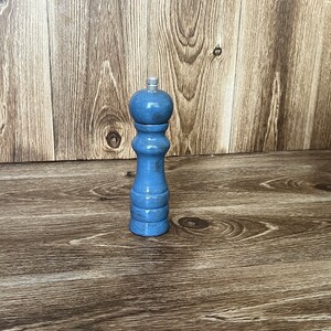 Puede incluir: Un molinillo de sal y pimienta de madera azul con un acabado desgastado.