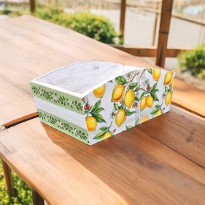 Puede incluir: Una caja de madera blanca con un borde rayado verde y blanco y un estampado de limones. La caja tiene la palabra "Citrus" impresa en la parte delantera.