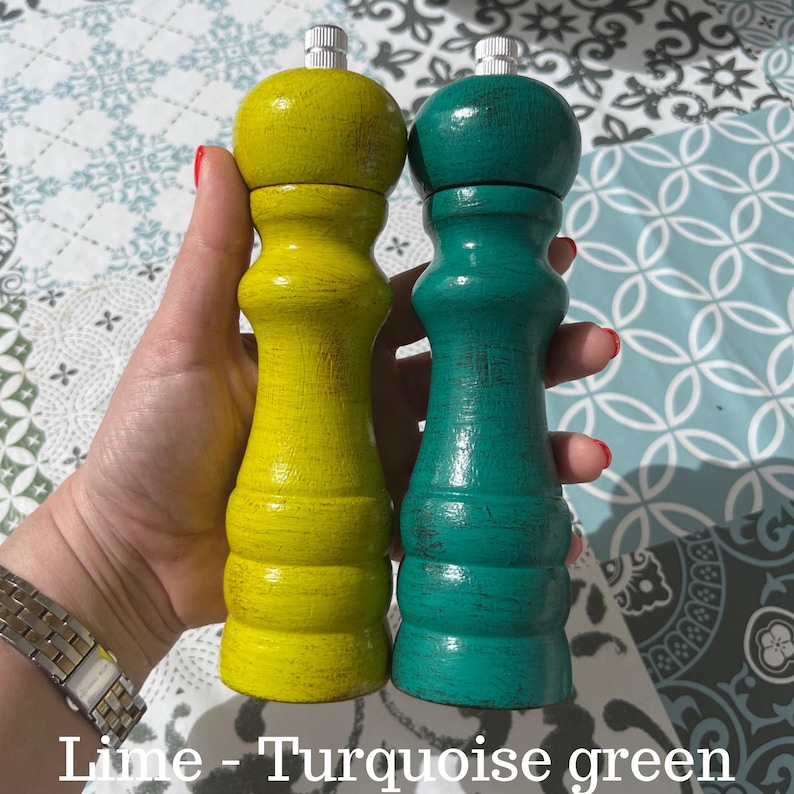 May include: Two wooden salt and pepper shakers, one lime green and one turquoise green. The shakers have a distressed paint finish.