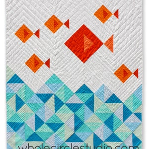 K&ouml;nnte beinhalten: Eine Steppdecke mit einem geometrischen Muster aus orangefarbenen Fischen, die &uuml;ber einem blauen und gr&uuml;nen Wellenmuster schwimmen. Die Steppdecke ist wei&szlig; mit einem Fischgratmuster und der Text "wholecirclestudio.com" ist in der rechten unteren Ecke gedruckt.