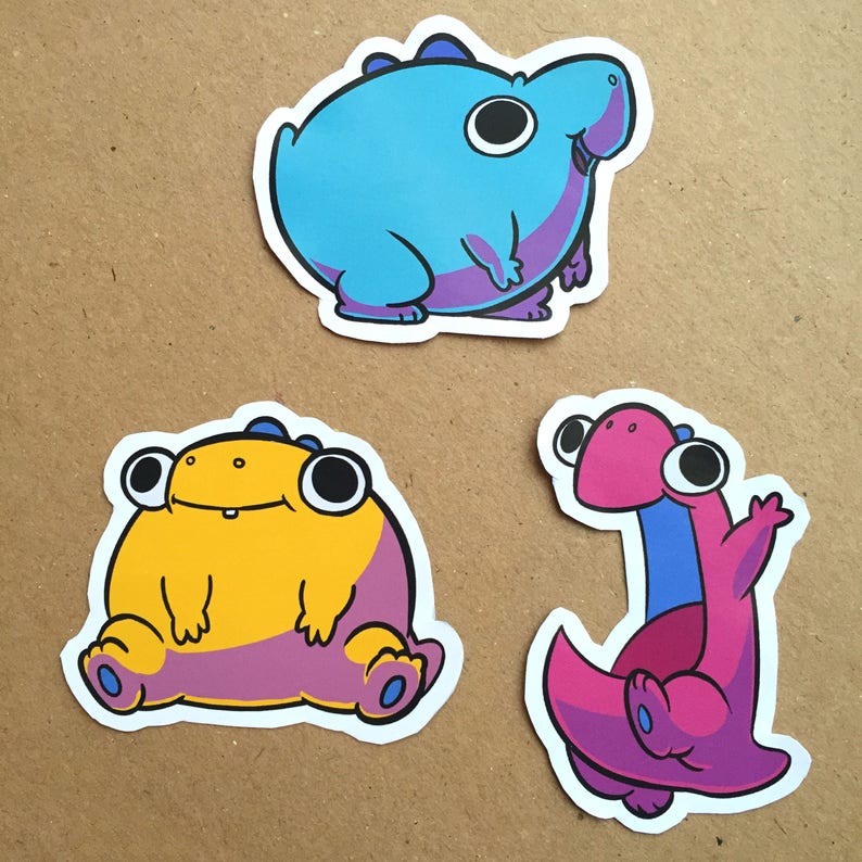 May include: Three cartoon stickers featuring different creatures. The first sticker is a blue creature with purple accents. The second sticker is a yellow creature with purple accents. The third sticker is a pink creature with blue accents.