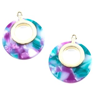 May include: Two round, gold-rimmed, pendant charms with a swirling pattern of teal, purple, and white.