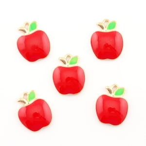May include: Five red apple charms with green leaves and gold accents. The charms are perfect for adding a touch of whimsy to jewelry or crafts.