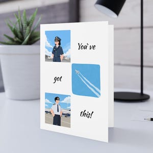 May include: A white greeting card featuring three illustrations: a pilot in a dark uniform, a pilot in a white shirt, and an airplane in a blue sky with contrails. The card includes the black text "You've got this!" arranged around the images.
