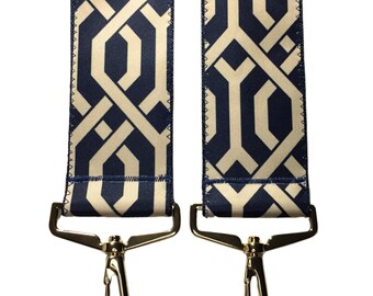 May include: Two gold-toned metal clips with a blue and cream geometric patterned strap attached to each.