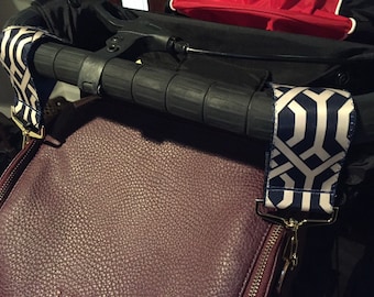 May include: A burgundy leather bag with gold zipper and two straps with a geometric pattern in navy blue and white.