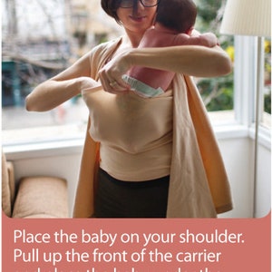 May include: A woman wearing a beige baby carrier, holding a baby. The carrier is a soft, wrap-style design. The image includes text that reads: "Place the baby on your shoulder. Pull up the front of the carrier and place the baby under the strapless part, sliding them into the space made."