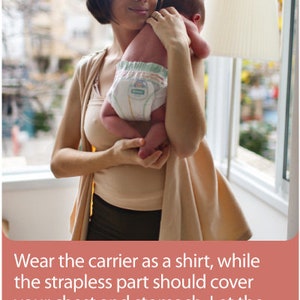 May include: A woman holding a baby wearing a diaper. The woman is wearing glasses and a beige top. The baby is being held in front of a window. The image includes text that reads, "Wear the carrier as a shirt, while the strapless part should cover your chest and stomach. Let the wings dangle to your sides."