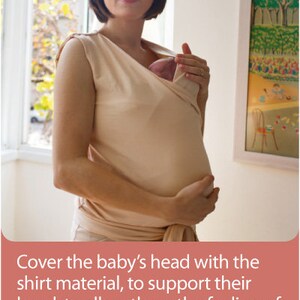 May include: A beige baby wrap carrier. The carrier is being used to hold a baby. The text in the image says to cover the baby's head with the shirt material to support their head, allowing them to feel enveloped securely.
