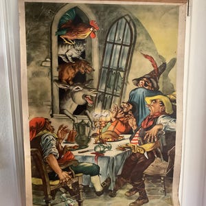 Puede incluir: Ilustración vintage que representa una escena animada con un burro, un gallo, un gato y un perro mirando por una ventana. Varias figuras están sentadas alrededor de una mesa, participando en una interacción dramática. La obra de arte está montada en un marco de madera.