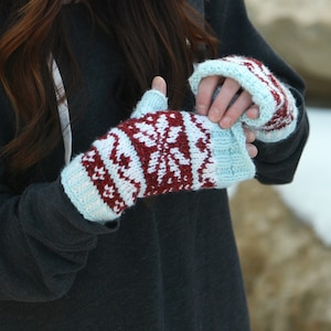 May include: A pair of fingerless gloves with a white, red and blue snowflake pattern.