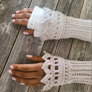 Könnte beinhalten: Ein Paar gestrickte Fingerlose Handschuhe mit einer gehäkelten Spitzenborte. Die Handschuhe sind hellbeige.