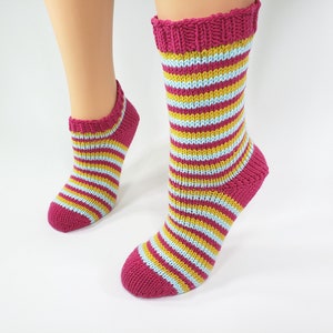 Puede incluir: Un par de calcetines de tobillo a rayas rosa, amarillo y azul.