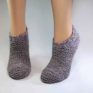 May include: A pair of gray knitted ankle socks. The socks are made with a textured stitch pattern.
