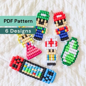 Puede incluir: Seis diseños de arte de píxeles hechos de cuentas de plástico coloridas, incluyendo personajes en rojo, verde, azul, amarillo, rosa y blanco. El texto PDF Pattern 6 Designs está superpuesto. Estas figuras de cuentas tienen estructuras de rejilla.