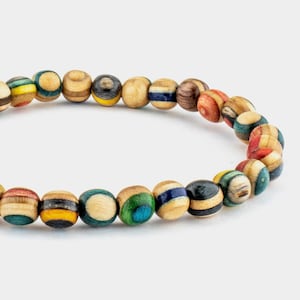 Könnte beinhalten: Ein farbenfrohes Holz-Armband mit runden Perlen. Die Perlen sind aus verschiedenen Holzarten gefertigt und haben eine Vielzahl von Farben und Mustern.