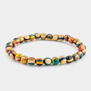 Peut inclure: Un bracelet en bois coloré avec des perles rondes. Les perles sont faites de différents types de bois et présentent une variété de couleurs et de motifs.