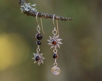 Asymmetrical solar earrings in stainless steel and bull's eye