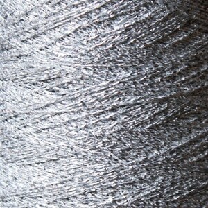 May include: Close-up of a spool of silver yarn. The yarn is tightly wound, showing a textured surface with a metallic sheen. The yarn appears to be made of a shiny, reflective material, ideal for crafting projects.