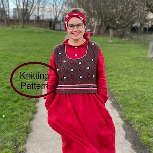 Puede incluir: Una mujer con un vestido rojo y un chaleco de punto marrón con detalles blancos y rojos. El chaleco presenta un diseño de punto trenzado y bolitas. También se ve un pañuelo rojo y el texto "Knitting Pattern" en un círculo.