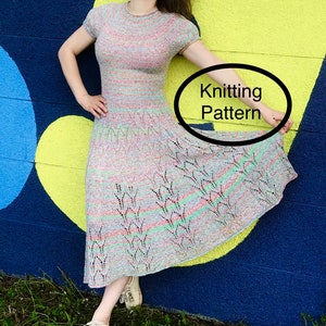 May include: A woman wearing a colorful, knitted dress with a lacy pattern. The dress has short sleeves and a round neckline. The woman is standing in front of a wall with a yellow heart painted on it. The text "Knitting Pattern" is written in a circle on the image.