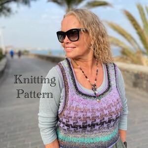 Può includere: Una donna indossa un gilet lavorato a maglia con un motivo colorato di viola, marrone e verde acqua. Il gilet è sovrapposto a una maglietta grigia a maniche lunghe. Il testo "Knitting Pattern" è visualizzato sull'immagine.