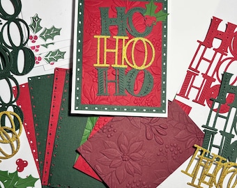 Könnte beinhalten: Eine handgefertigte Grußkarte mit dem Text HO HO HO in grünem und goldenem Glitzer, geschichtet auf einem roten, geprägten Hintergrund mit Weihnachtsstern-Mustern. Das Set enthält passenden Karton, Umschläge und Stechpalmen-Ausschnitte.