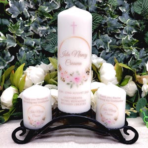 Può includere: Tre candele bianche con disegni floreali e dettagli dorati. La candela centrale è più alta e ha il testo "Isla Nancy Creaven" e "Nata: 22 agosto 2023 Padrini: Rachel Monaghan Benjamin Creaven". Le candele più piccole hanno il testo "Grazie Benjamin per essere il mio padrino" e "Grazie Rachel per essere la mia madrina".