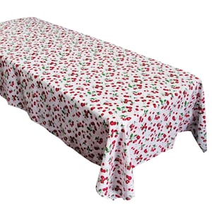 May include: White tablecloth with a red cherry pattern. The tablecloth is rectangular and has a smooth texture.