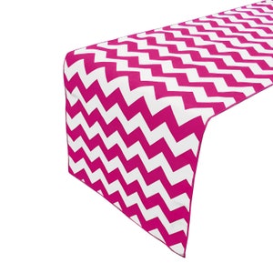 Puede incluir: Caminero de mesa en chevron rosa y blanco. El camino de mesa tiene un patrón de zigzag.
