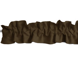 May include: A brown fabric valance with a ruffled edge. The valance is made of a textured fabric and is perfect for adding a touch of elegance to any window.