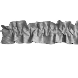 May include: A gray fabric valance with a ruffled edge. The valance is made of a textured fabric and is gathered in the center.