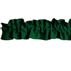 May include: A dark green fabric valance with a ruffled edge. The valance is made of a textured fabric and is perfect for adding a touch of elegance to any window.