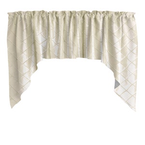 May include: Cream-colored valance with a diamond pattern. The fabric is gathered at the top and has a scalloped bottom edge. The valance is made of a soft, textured material and is designed to be hung over a window.