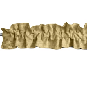 May include: A gold-colored fabric valance with a ruffled edge. The valance is made of a textured fabric and is gathered in the center.