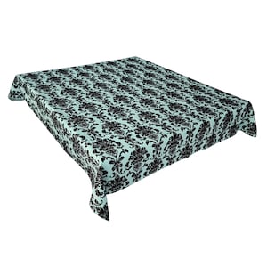 Puede incluir: Un mantel rectangular con un patrón floral negro repetido sobre un fondo azul claro. El mantel está hecho de una tela suave y drapeada, adecuado para una mesa de comedor u otra superficie.