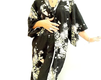 May include: A black kimono with a floral print. The kimono has a long, flowing silhouette and is tied at the waist with a sash.