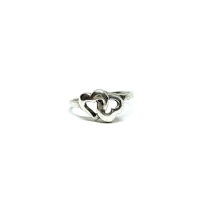 May include: A silver ring featuring two interlocked heart shapes.