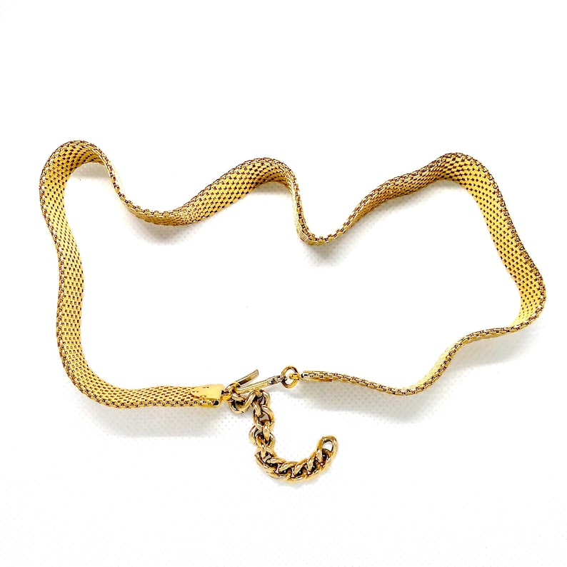 May include: A gold chain necklace with a mesh design and a lobster clasp closure.