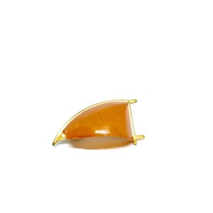 May include: A gold-toned metal frame with a curved amber-coloured glass insert. The frame is designed to hold a watch strap.