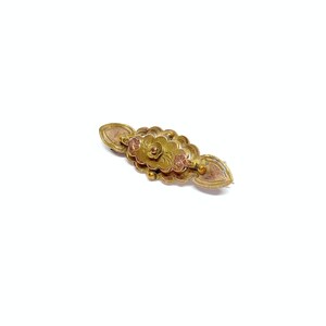 May include: A gold-toned brooch with a floral design. The brooch has a central flower with two smaller flowers on either side. The flowers are raised and have a textured surface.