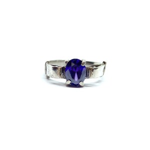 May include: A silver ring with a dark purple oval gemstone.