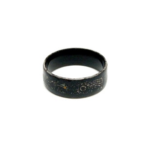 K&ouml;nnte beinhalten: Ein schwarzer Metallring mit einem dekorativen Design. Der Ring ist abgenutzt und hat einen Used-Look.